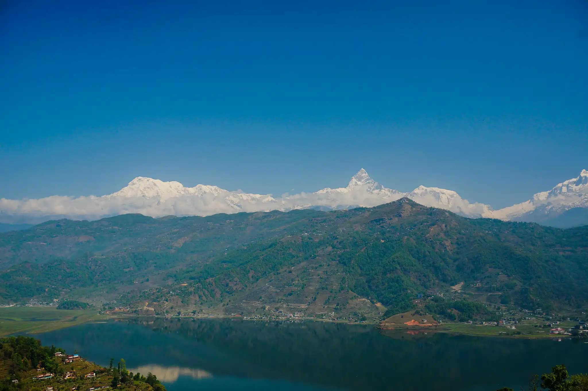 view of fewa lake and mountain range from pokhara, nepal